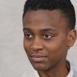 Joyful black young-adult male with short  brown hair and brown eyes