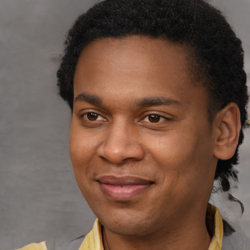 Joyful black adult male with short  brown hair and brown eyes