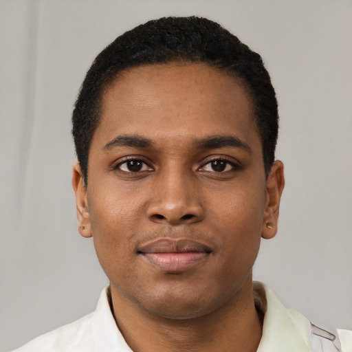 Joyful black young-adult male with short  brown hair and brown eyes