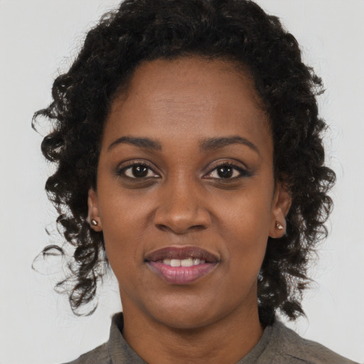 Joyful black young-adult female with long  brown hair and brown eyes