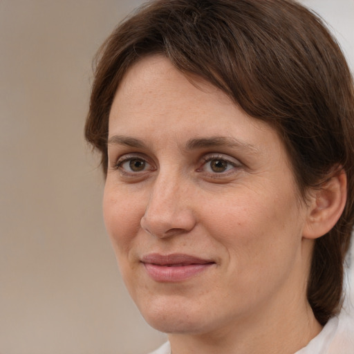 Joyful white adult female with medium  brown hair and brown eyes