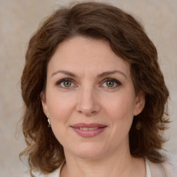 Joyful white young-adult female with medium  brown hair and green eyes