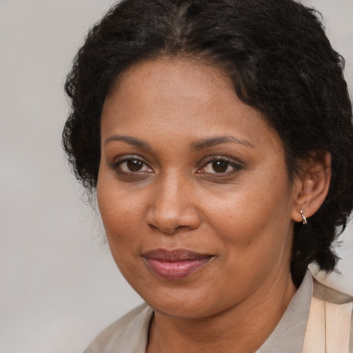Joyful black adult female with medium  brown hair and brown eyes