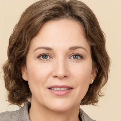 Joyful white adult female with medium  brown hair and grey eyes