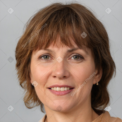 Joyful white adult female with medium  brown hair and green eyes