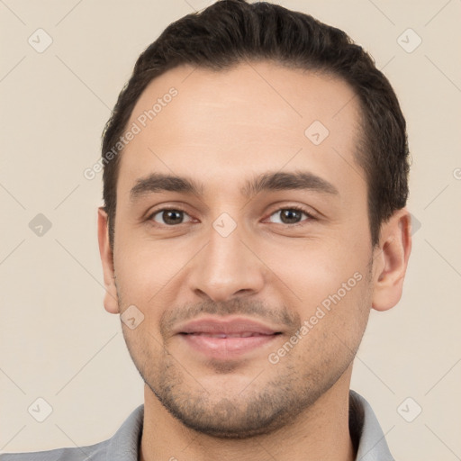 Joyful white young-adult male with short  black hair and brown eyes