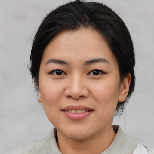 Joyful asian young-adult female with medium  brown hair and brown eyes