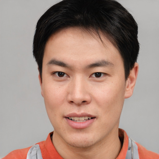 Joyful asian young-adult male with short  brown hair and brown eyes