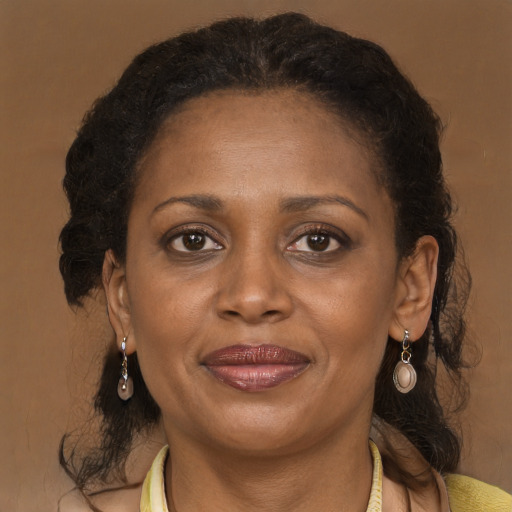 Joyful black adult female with long  brown hair and brown eyes
