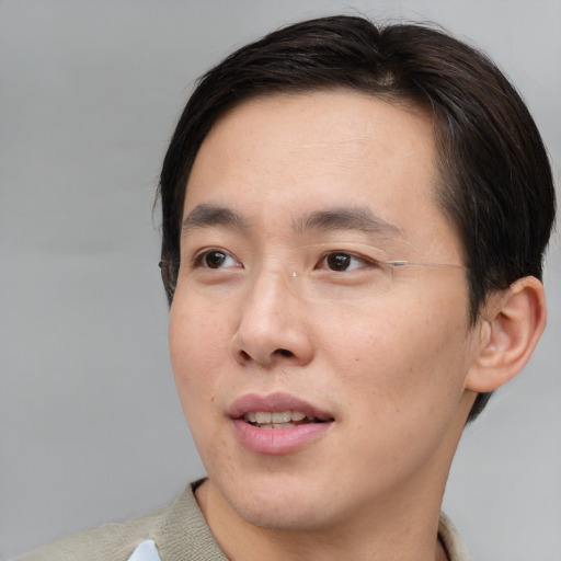 Joyful asian young-adult male with short  brown hair and brown eyes