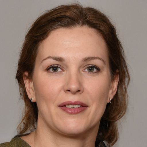 Joyful white adult female with medium  brown hair and blue eyes