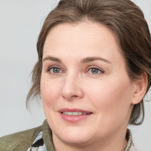 Joyful white adult female with medium  brown hair and grey eyes