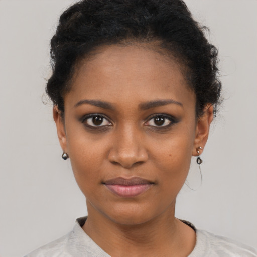 Joyful black young-adult female with short  black hair and brown eyes