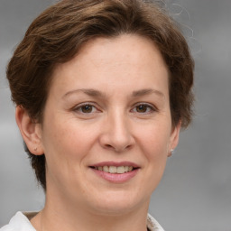 Joyful white adult female with medium  brown hair and grey eyes