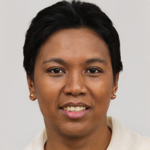 Joyful black adult female with short  black hair and brown eyes