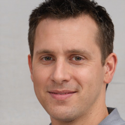 Joyful white adult male with short  brown hair and brown eyes