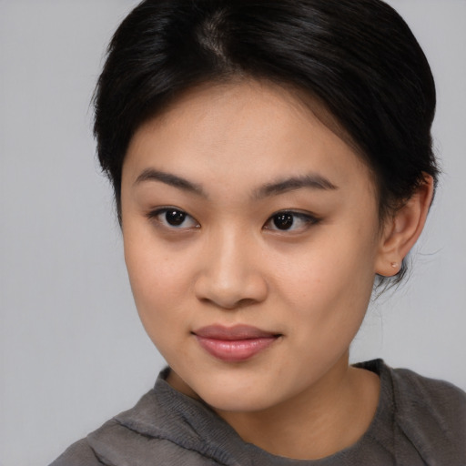Joyful asian young-adult female with medium  brown hair and brown eyes