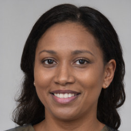 Joyful latino adult female with long  brown hair and brown eyes