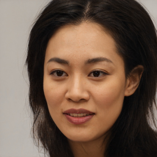 Joyful asian young-adult female with long  brown hair and brown eyes