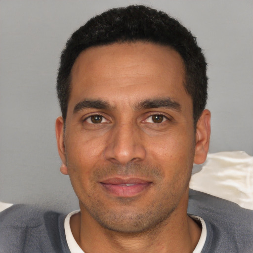Joyful white young-adult male with short  black hair and brown eyes