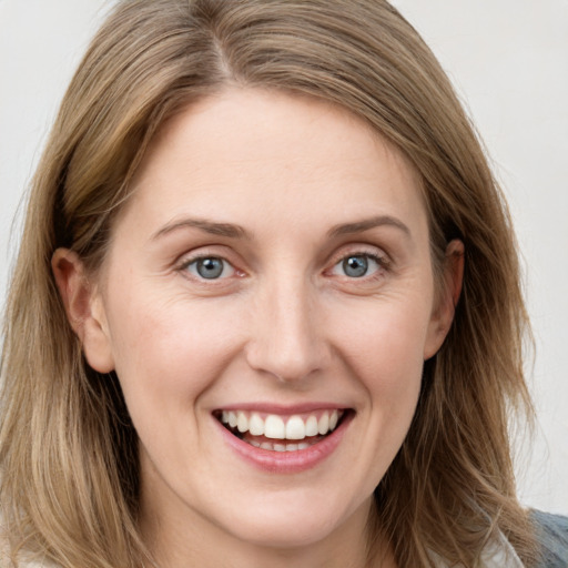 Joyful white young-adult female with long  brown hair and blue eyes