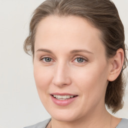 Joyful white young-adult female with medium  brown hair and blue eyes