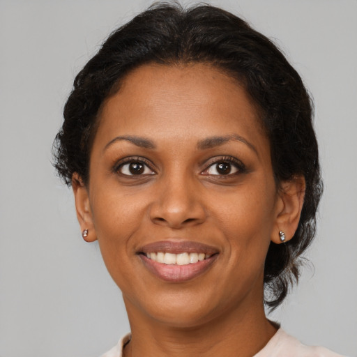 Joyful black adult female with medium  brown hair and brown eyes