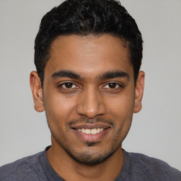 Joyful latino young-adult male with short  black hair and brown eyes