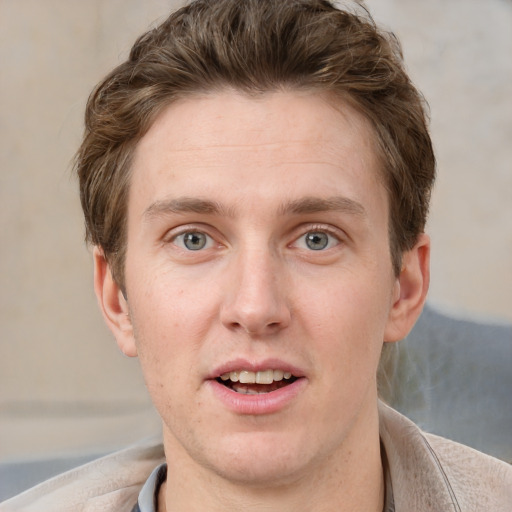 Joyful white young-adult male with short  brown hair and grey eyes