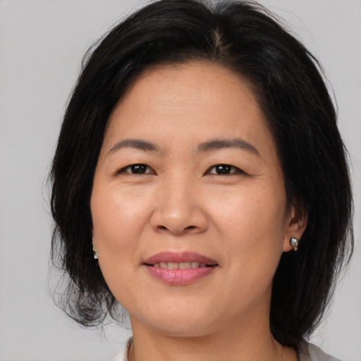 Joyful asian young-adult female with medium  brown hair and brown eyes