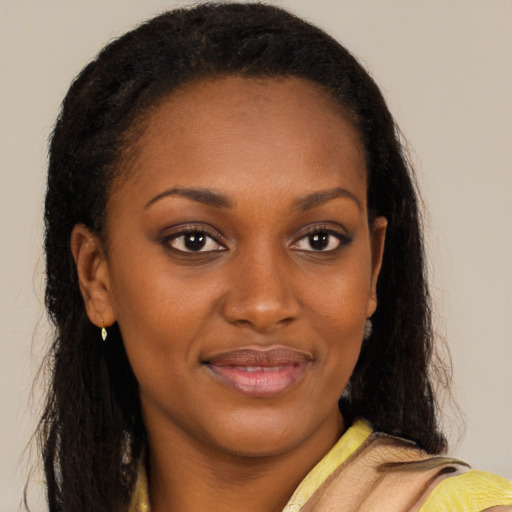 Joyful black young-adult female with long  brown hair and brown eyes