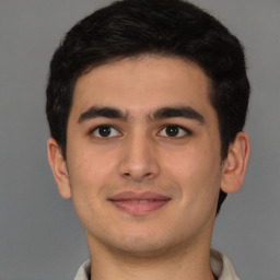 Joyful latino young-adult male with short  brown hair and brown eyes