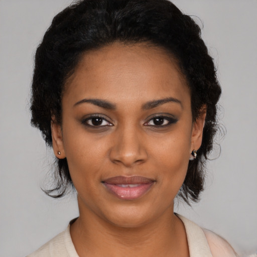 Joyful black young-adult female with short  black hair and brown eyes