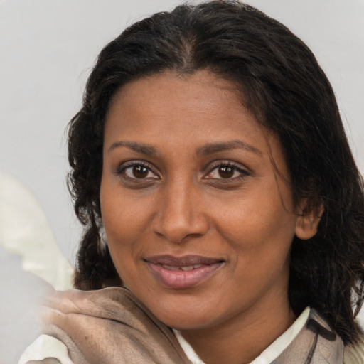 Joyful latino adult female with medium  brown hair and brown eyes