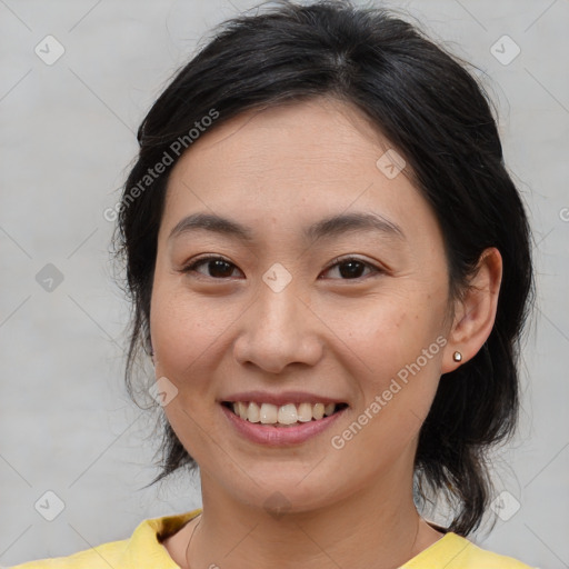 Joyful asian young-adult female with medium  brown hair and brown eyes