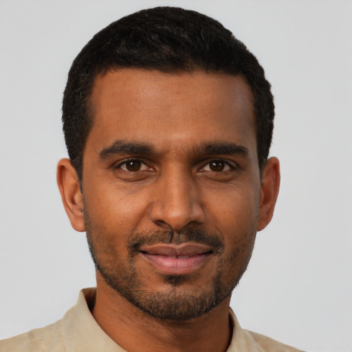 Joyful black young-adult male with short  black hair and brown eyes