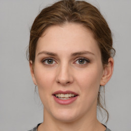 Joyful white young-adult female with medium  brown hair and green eyes