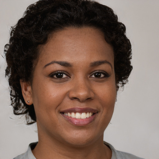 Joyful black young-adult female with short  brown hair and brown eyes