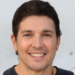 Joyful white adult male with short  brown hair and brown eyes