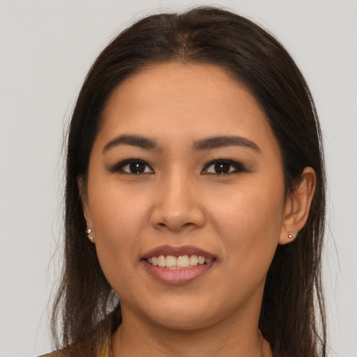 Joyful asian young-adult female with long  brown hair and brown eyes