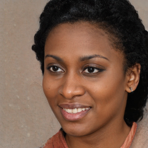 Joyful black young-adult female with short  black hair and brown eyes