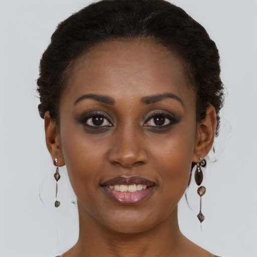 Joyful black young-adult female with long  brown hair and brown eyes
