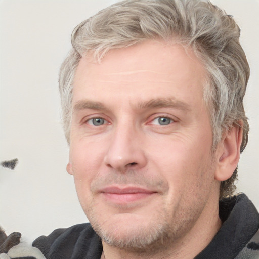 Joyful white adult male with short  brown hair and blue eyes