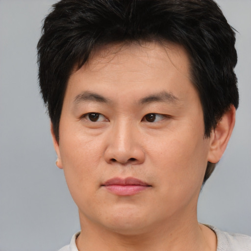 Joyful asian young-adult male with short  brown hair and brown eyes
