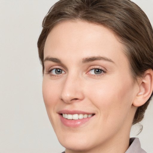 Joyful white young-adult female with medium  brown hair and grey eyes