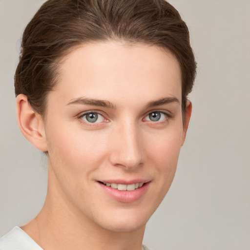 Joyful white young-adult female with short  brown hair and grey eyes