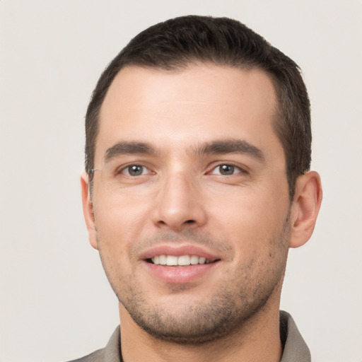 Joyful white young-adult male with short  brown hair and brown eyes