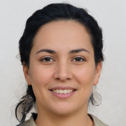 Joyful latino young-adult female with medium  brown hair and brown eyes