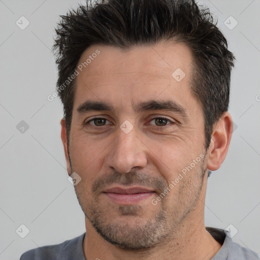 Joyful white adult male with short  black hair and brown eyes