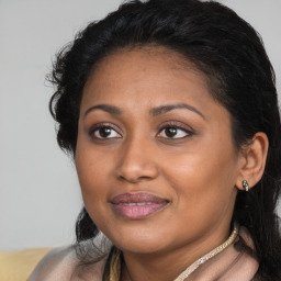 Joyful black young-adult female with long  brown hair and brown eyes